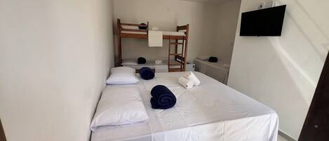 A single bed with white bedding, a wooden headboard, and a small bedside table with a lamp.
