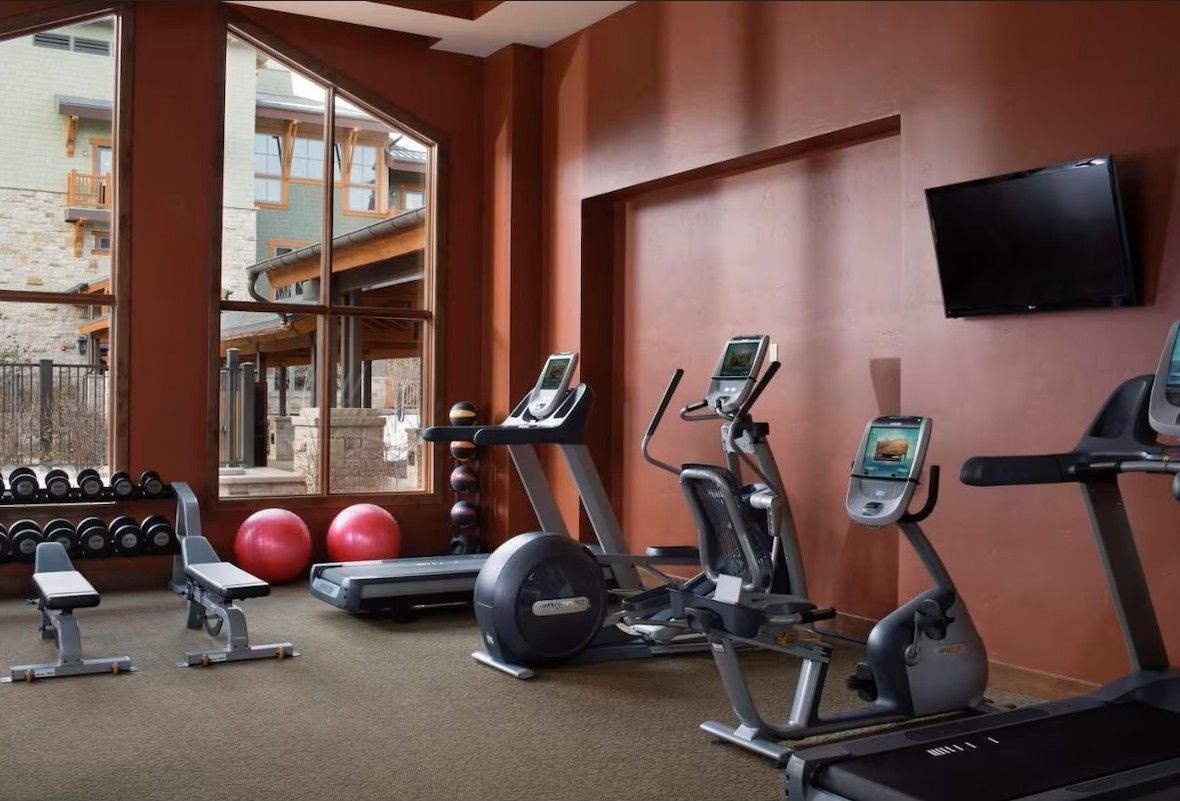 A gym with treadmills, elliptical machines, and free weights.