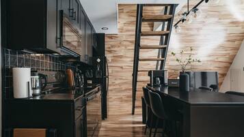 Eine moderne Küche mit dunklen Schränken, einer Holz-Akzentwand und einer eingebauten Leiter.