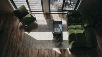 A modern living room with a green sofa, a matching armchair, and a coffee table.