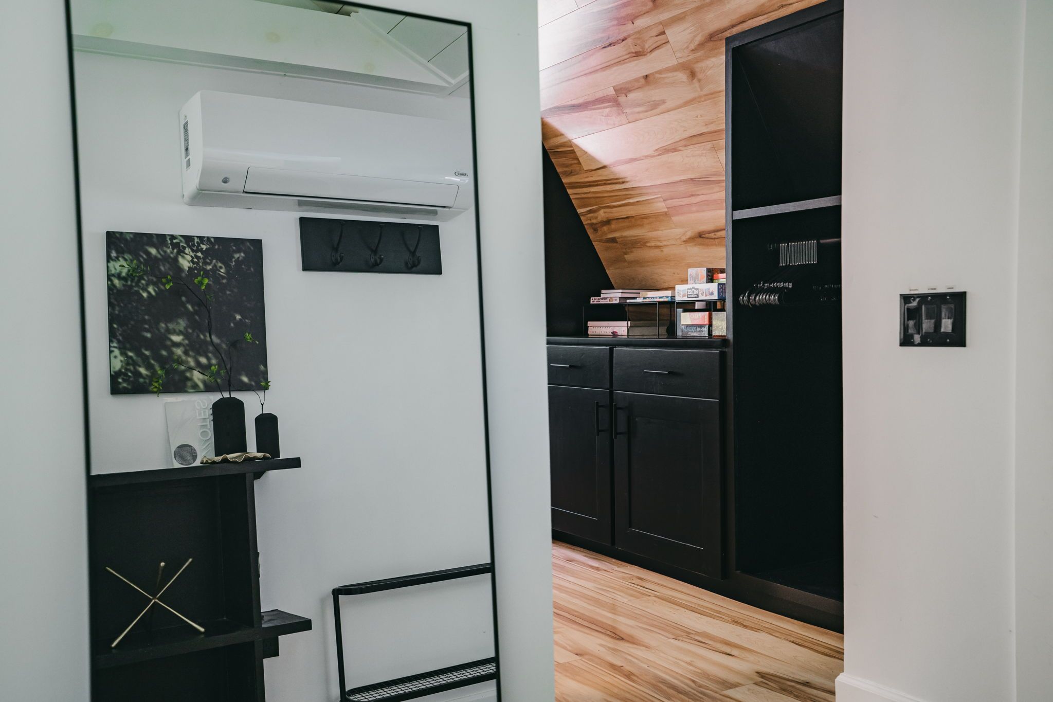 A modern kitchen with black cabinets, a wooden ceiling, and a black refrigerator.