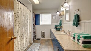 Une salle de bain avec un rideau de douche, un lavabo, un miroir et un porte-serviettes.