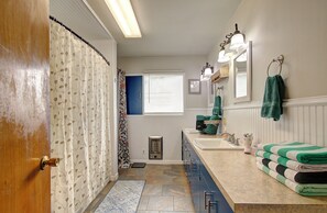 A bathroom with a shower curtain, a sink, a mirror, and a towel rack. - Spacious 5 bdrm house in charming Battle Ground with hot tub and large property (Battle Ground)