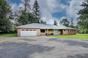 A single-story house with a garage, a covered porch, and a gravel driveway. - Spacious 5 bdrm house in charming Battle Ground with hot tub and large property (Battle Ground)