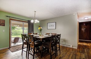 A dining room with a table set for six, a chandelier, and a framed quote on the wall. - Spacious 5 bdrm house in charming Battle Ground with hot tub and large property (Battle Ground)