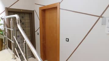 Un escalier avec des rampes en métal menant à une porte portant une plaque avec un numéro.