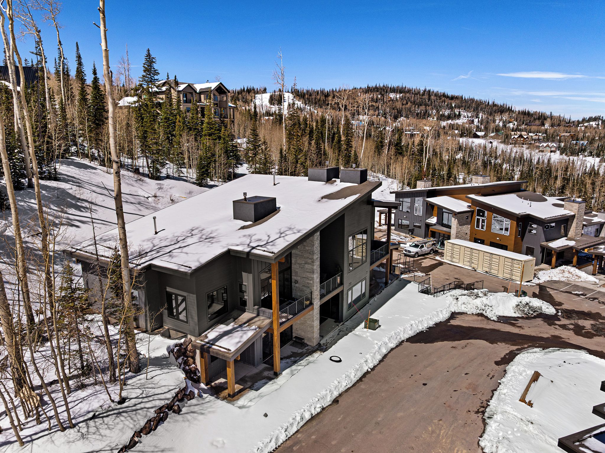 A modern multi-story building with a ski slope in the background.