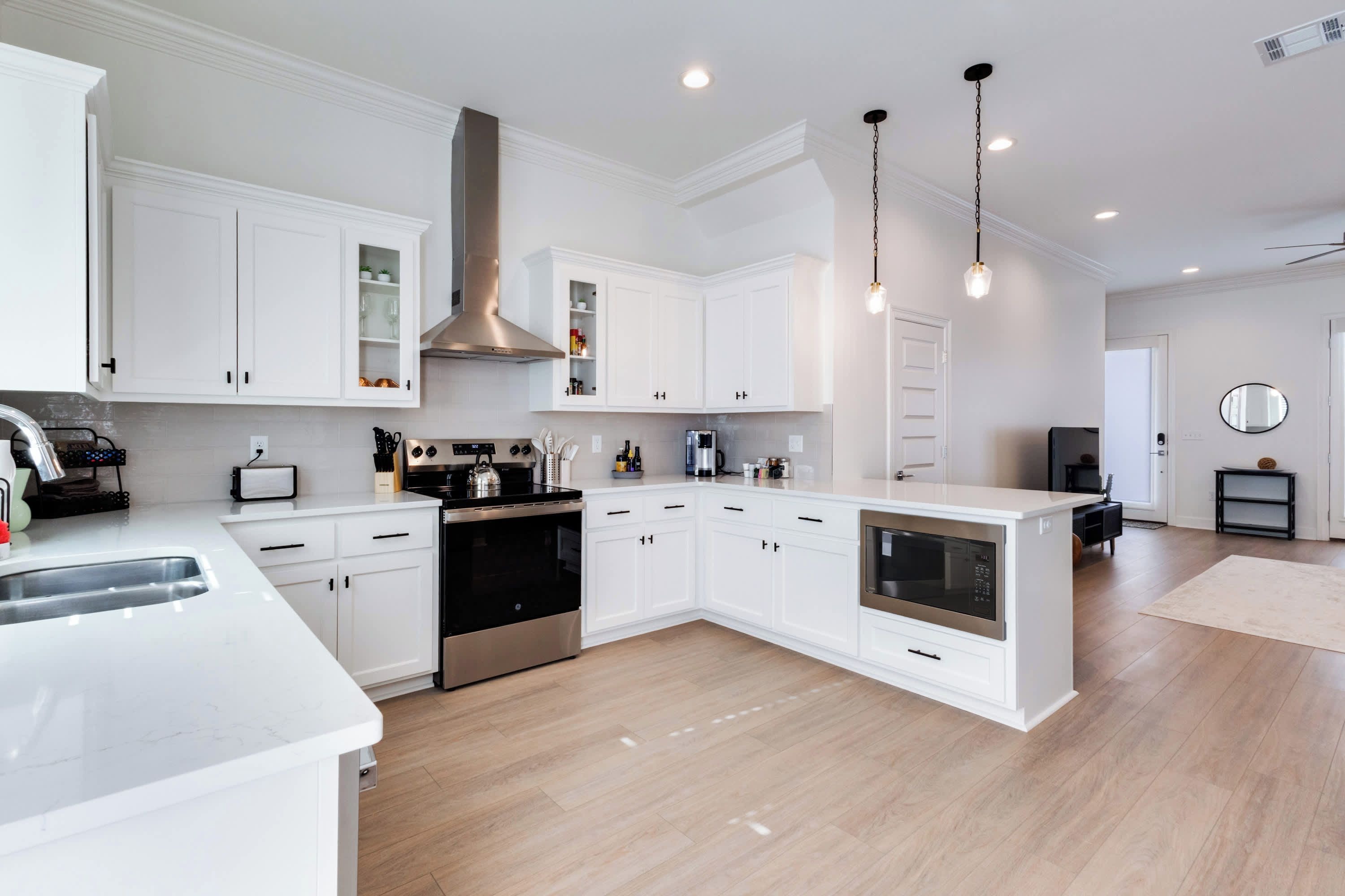 A modern kitchen with white cabinetry, stainless steel appliances, and a central island.