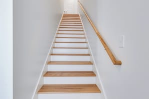 Eine Treppe mit Holzboden und einem hölzernen Geländer.