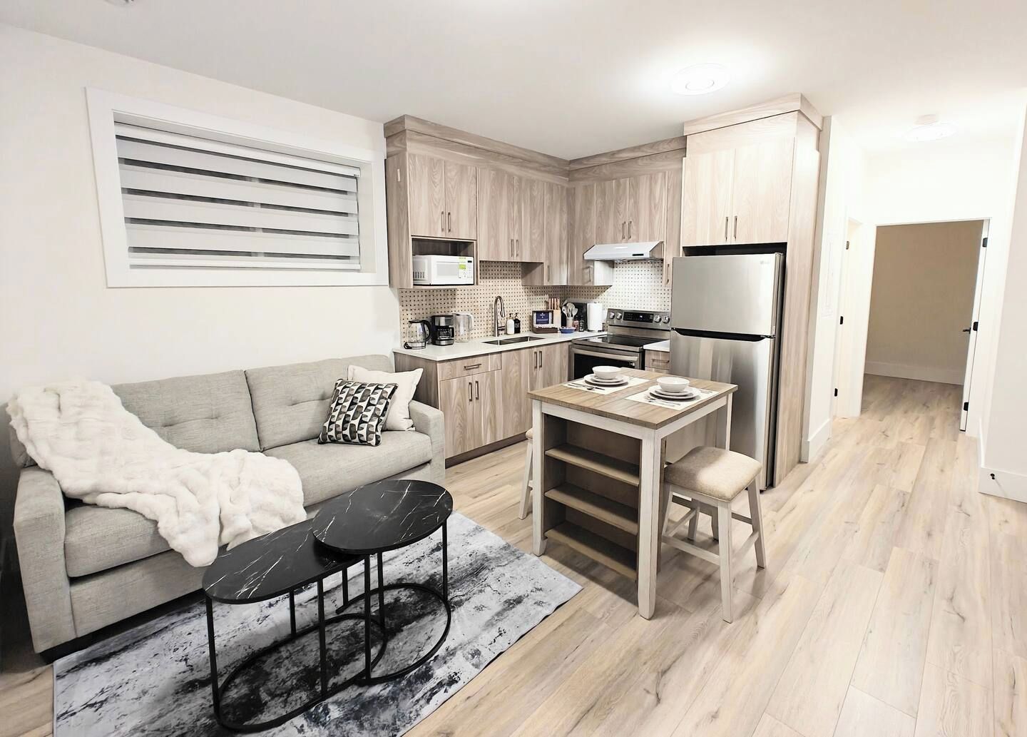 A compact living space with a kitchenette, a sofa, a coffee table, and a dining area.