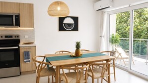 Een moderne keuken met een eethoek, een hanglamp en een airconditioning.