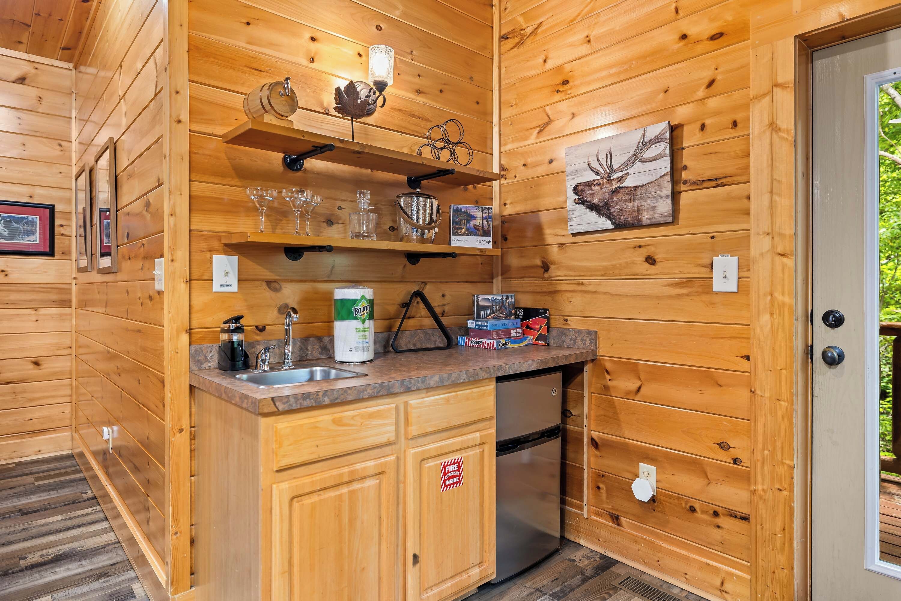 L’intérieur d’une cabane en bois comprend un espace cuisine équipé d’un évier, de placards et d’un réfrigérateur.