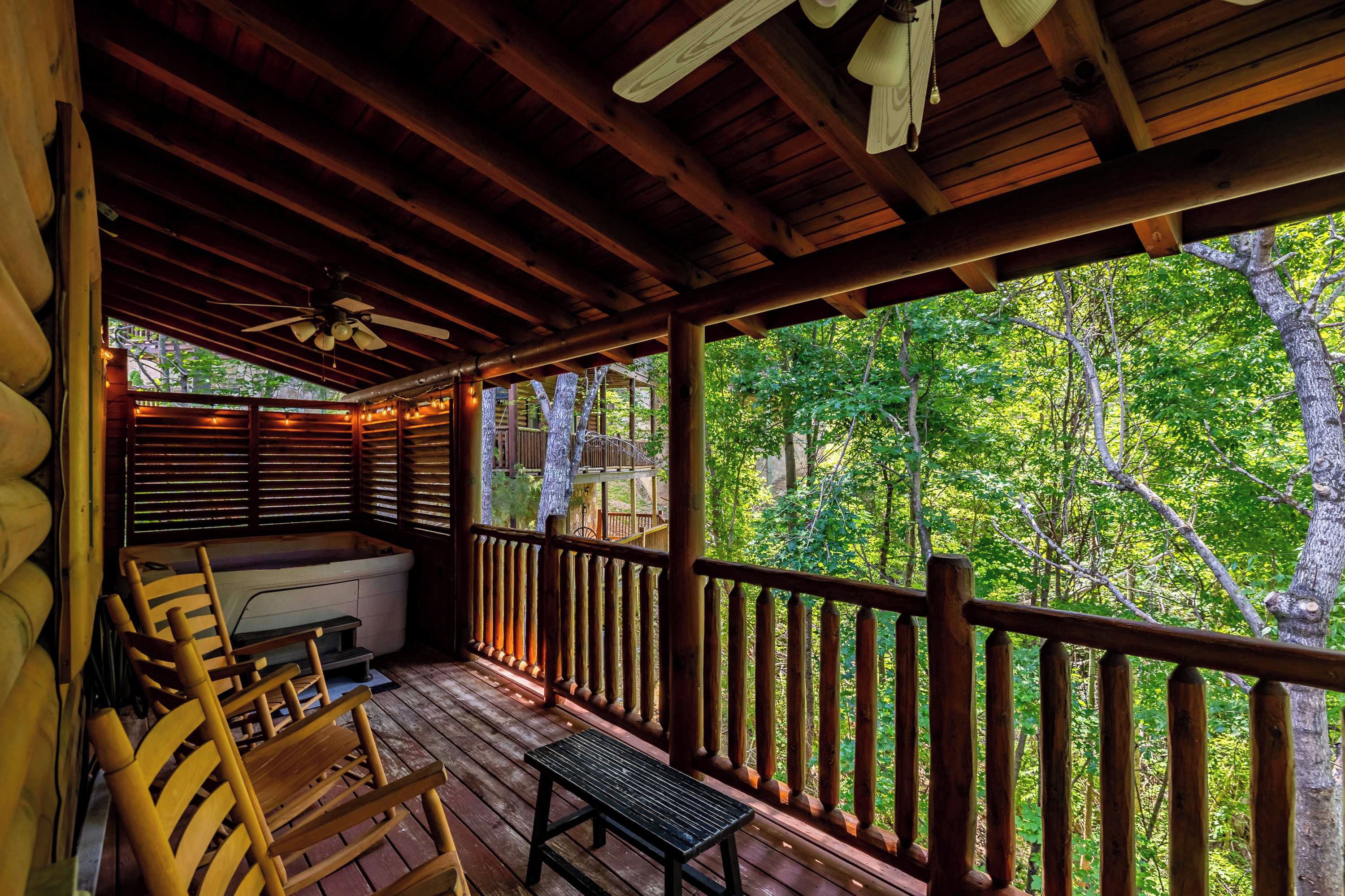 Une terrasse en bois avec un jacuzzi, des chaises en bois et un banc.