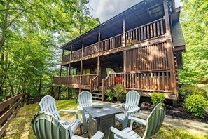 Une cabane en bois dotée d’un balcon, entourée de verdure.