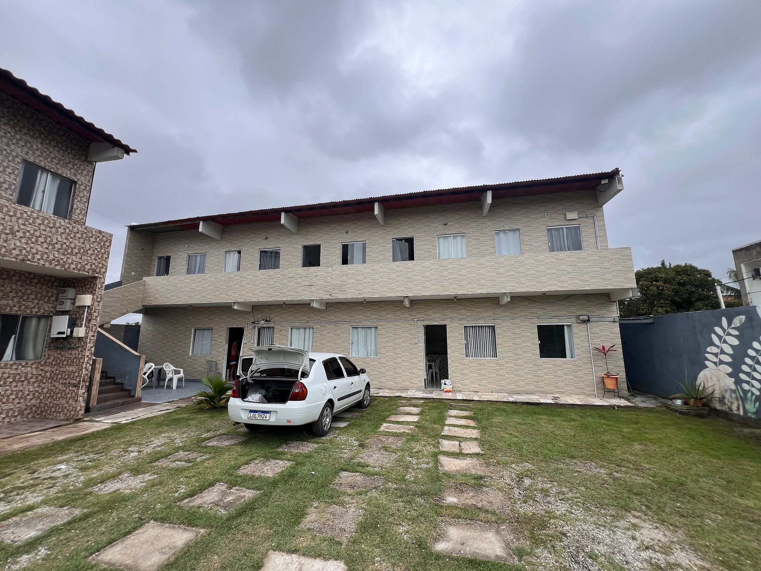 Un edificio residenziale a due piani con un'auto parcheggiata nel vialetto.