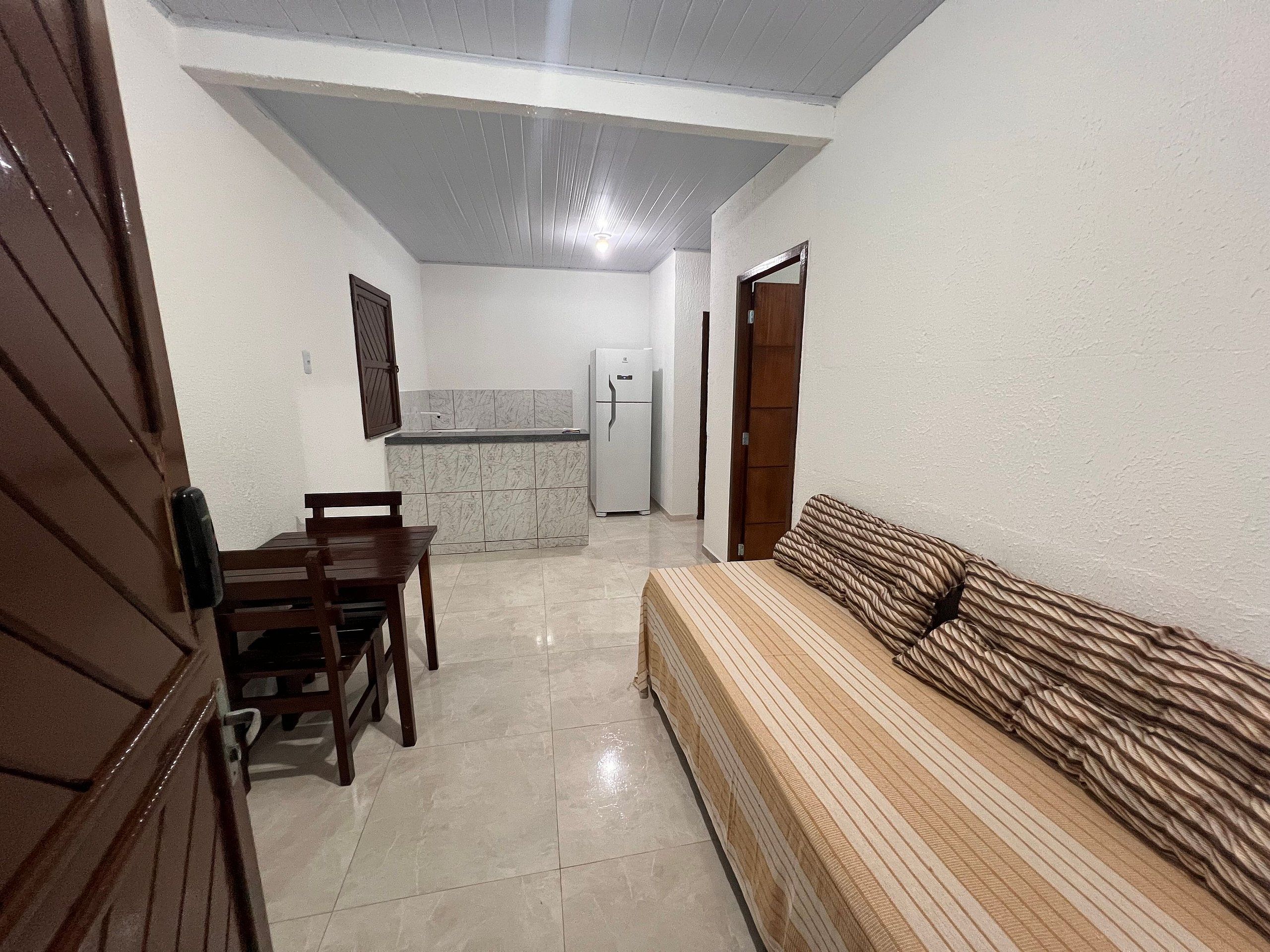 Un espacio habitable compacto con comedor, kitchenette y sofá.