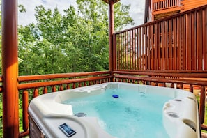 A hot tub on a wooden deck with a view of trees. - 6 En-Suite Bedrooms, Indoor Pool, Theater, Hot Tub, Epic Mountain Views (Sevierville)
