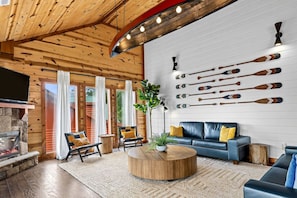 A cozy living room with a fireplace, a sofa, and a coffee table. - 6 Ensuite Bedrooms | Private Indoor Heated Pool, Theater, Hot Tub & Mountain Views (Sevierville)