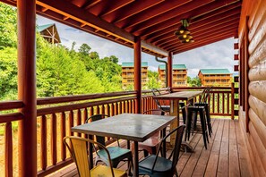 Eine Holzterrasse mit Sitzgelegenheiten im Freien und Blick auf einen Gebäudekomplex.