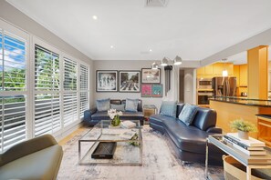 A modern living room with a sofa, coffee table, and artwork on the wall. - Dolphin Retreat - 4 Bedrooms House with Private Pool (Oakland Park)