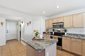 A modern kitchen with granite countertops, stainless steel appliances, and wooden cabinets. - Staycation Home in Arizona|  Pool w/ BBQ (Glendale)