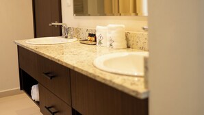 Un baño moderno con tocador doble, espejo y candelabro.