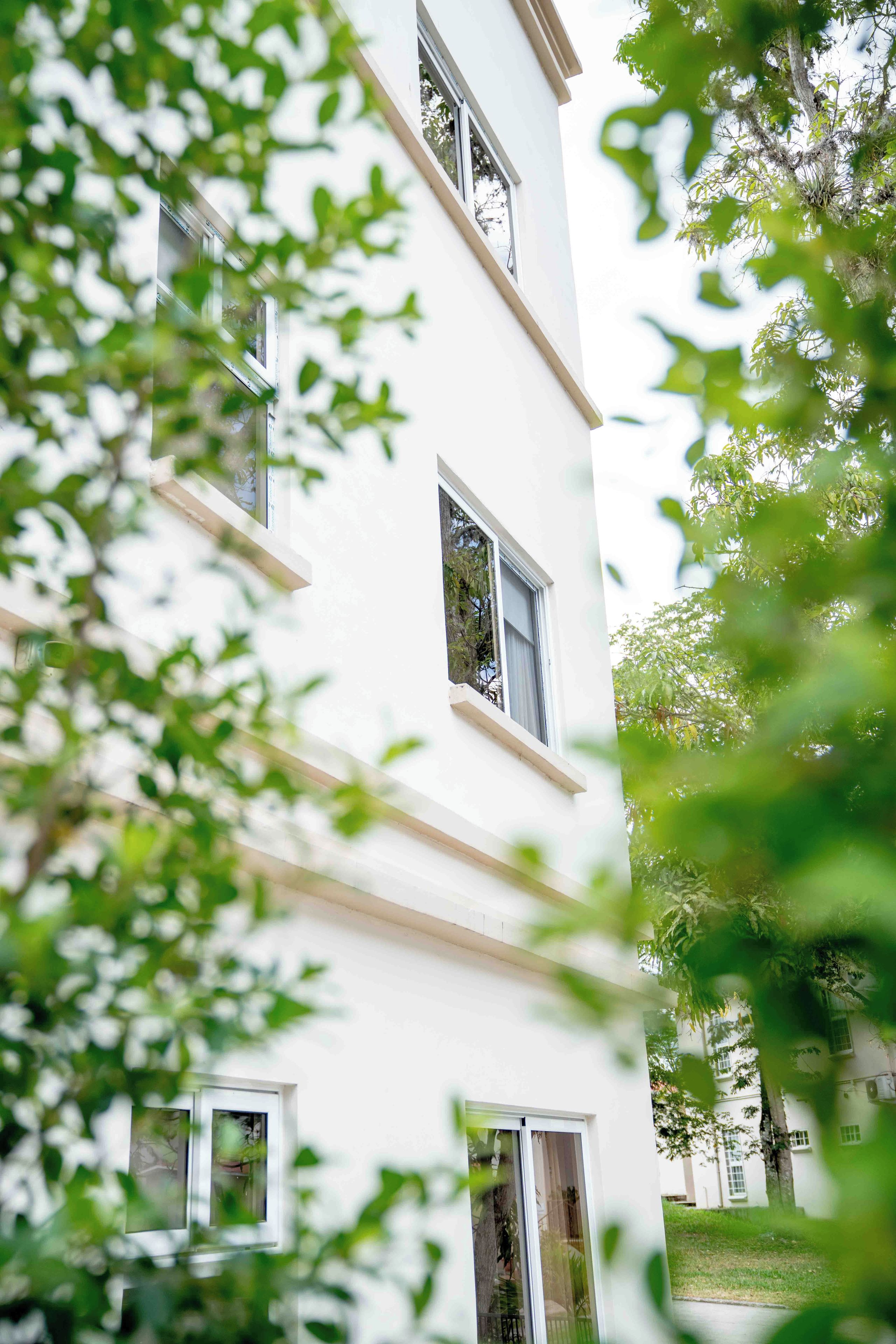 Um edifício com vários andares, grandes janelas e uma varanda.