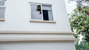 Un edificio de varios pisos con paredes exteriores blancas y numerosas ventanas.