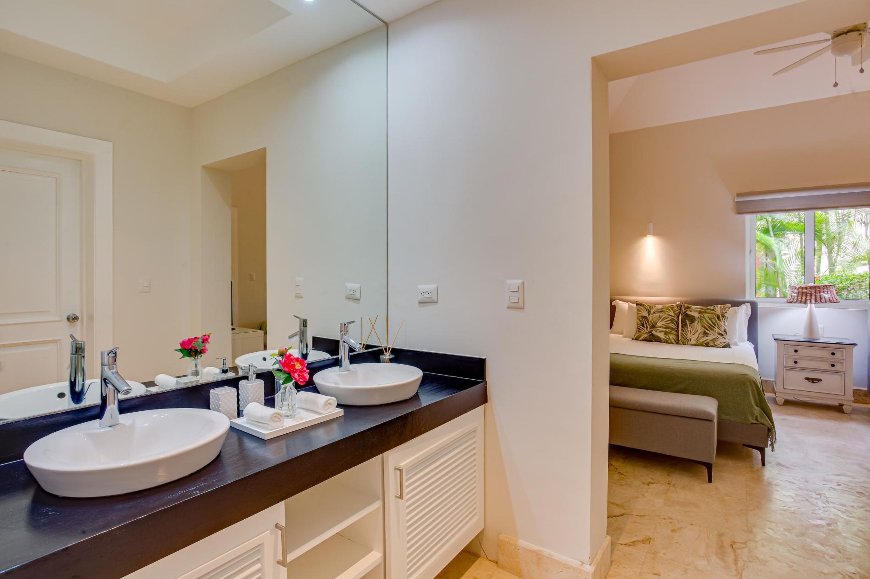 Une salle de bain moderne avec deux lavabos, un grand miroir et une douche à l’italienne.