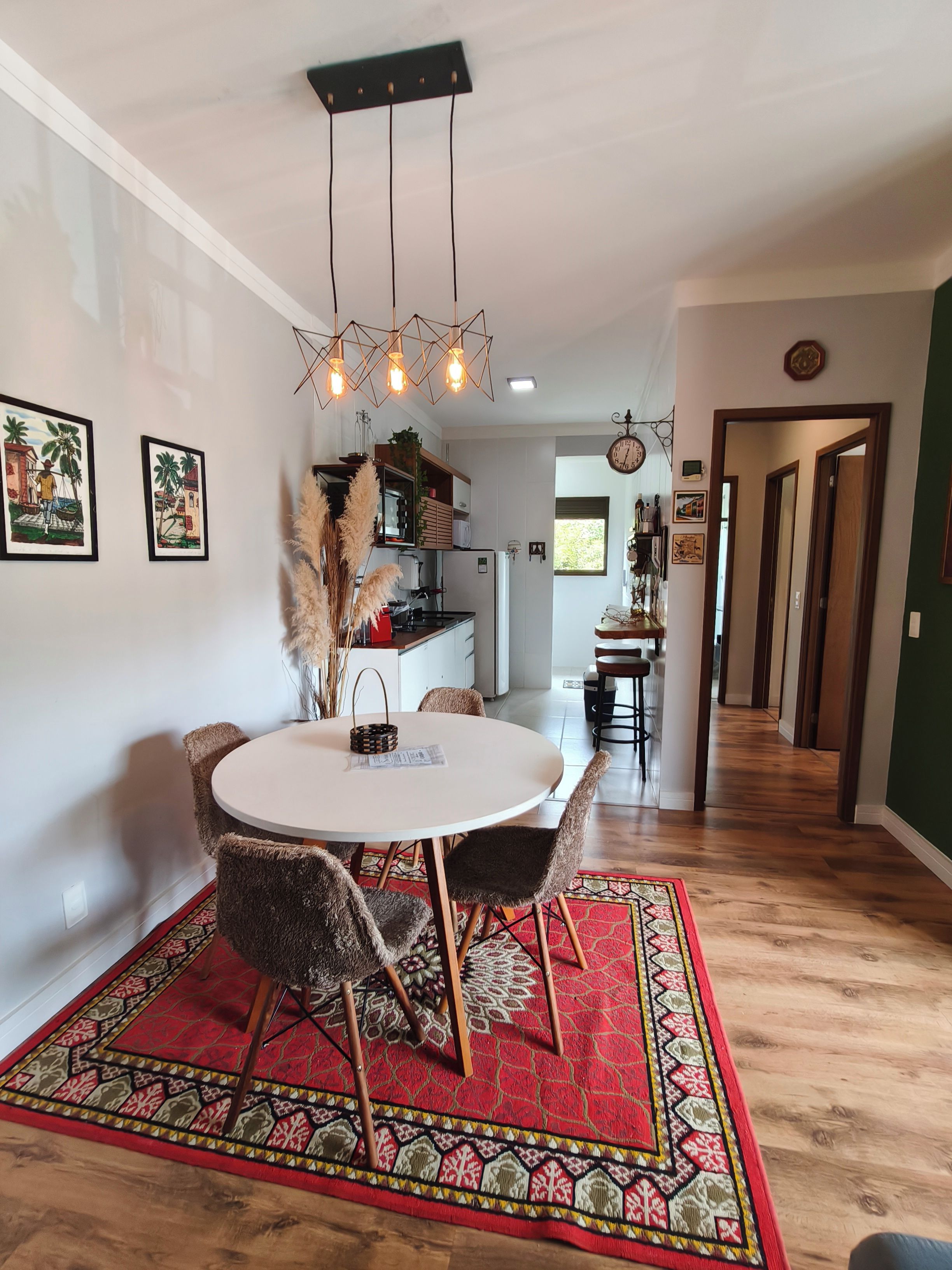 A dining area with a round table, chairs, and a patterned rug.