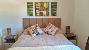 Un lit avec une tête de lit, deux oreillers et deux tables de chevet avec des lampes.
