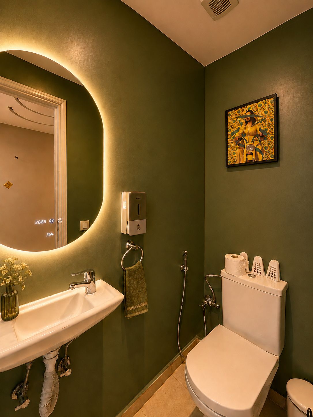 Un bany amb un vàter blanc, un lavabo, una dutxa i un dispensador de paper higiènic fixat a la paret.