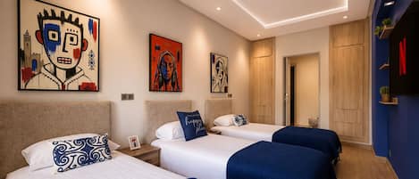 Une chambre d’hôtel avec trois lits, une grande fenêtre et des œuvres d’art accrochées aux murs.