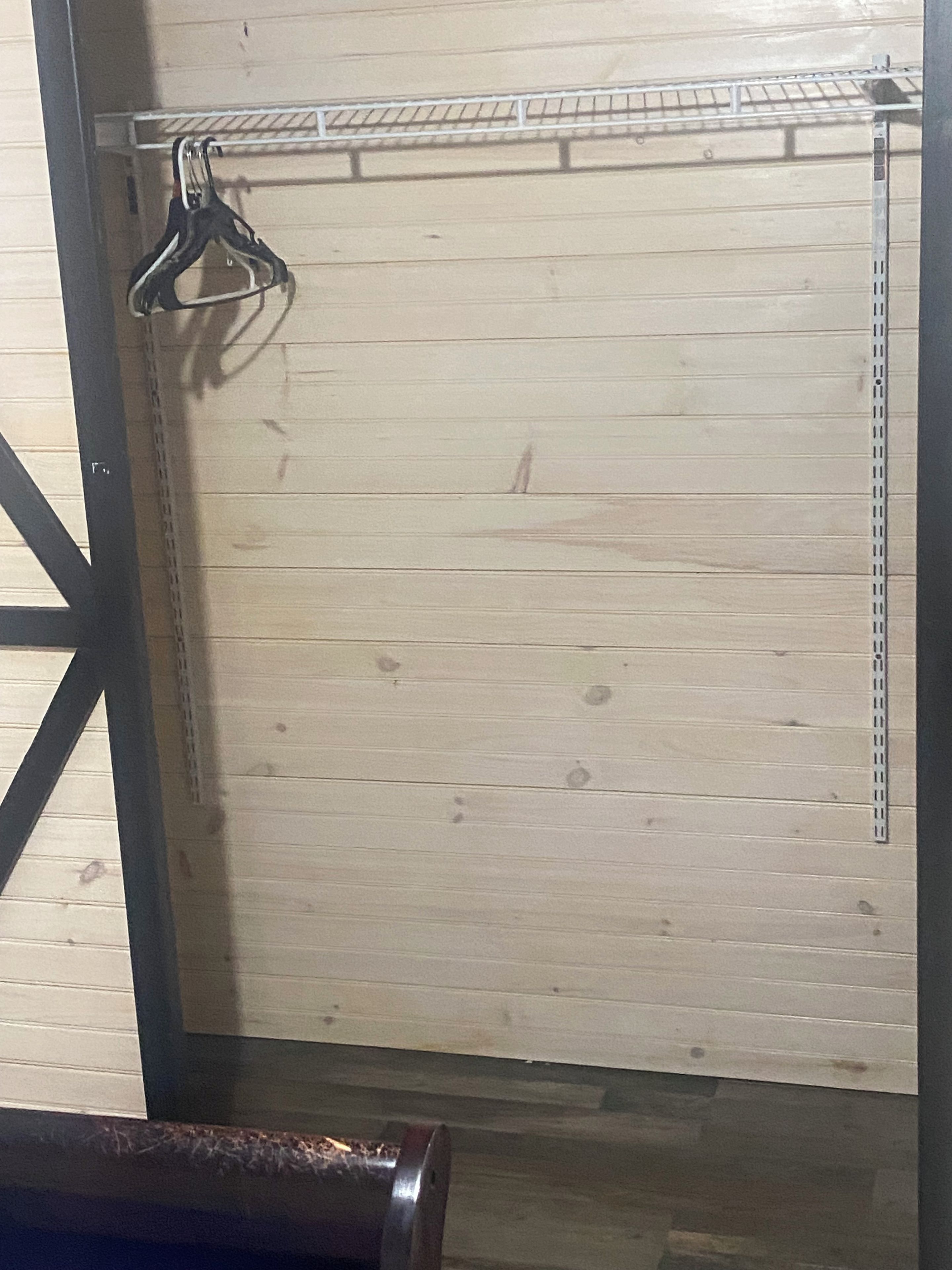Une porte en bois avec une poignée en métal et une étagère en métal au-dessus.
