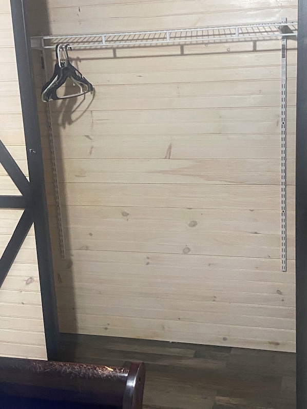 A wooden door with a metal handle and a metal shelf above it.