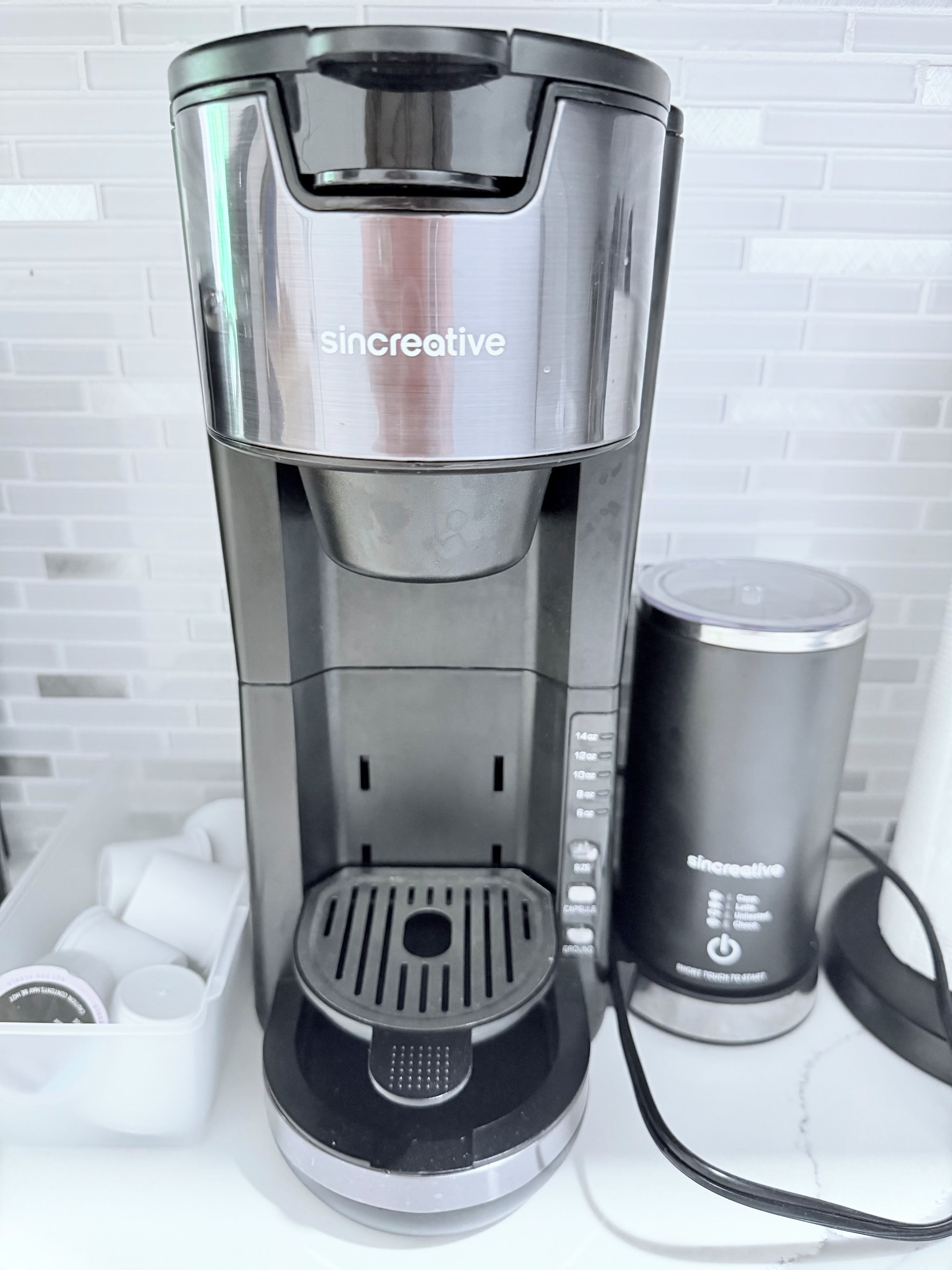 A coffee maker with a water reservoir and a coffee pod holder.