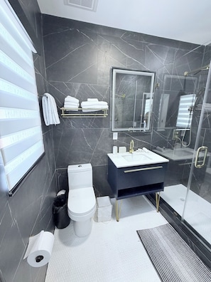 A modern bathroom with a toilet, sink, and shower. - Cozy studio apartment in tranquil Tavernier with AC and kitchen. (Tavernier)