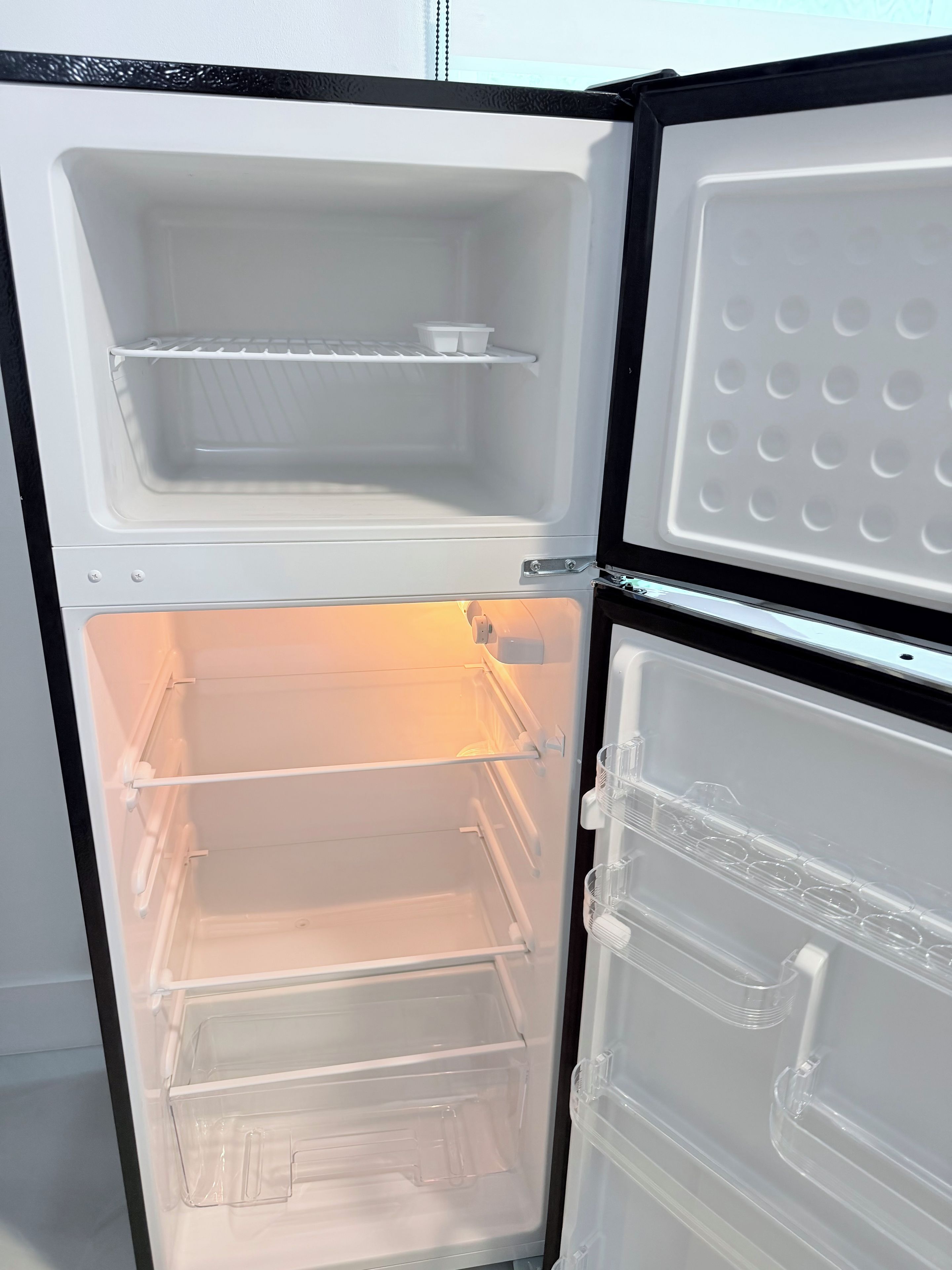 An open refrigerator with multiple shelves and compartments.