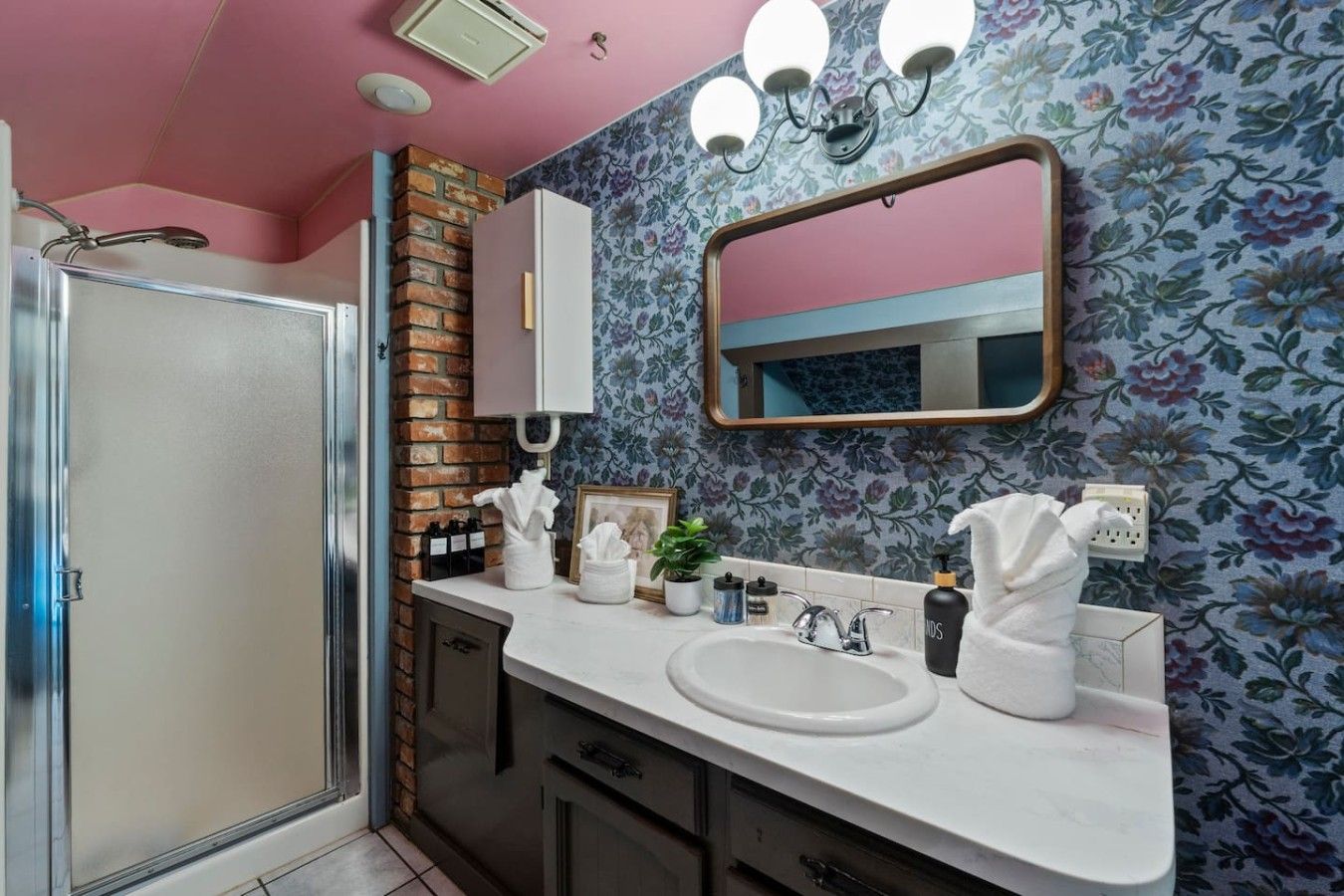 Une salle de bain équipée d’une douche, d’un lavabo, d’un miroir et d’un porte-serviettes.
