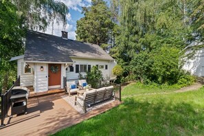 A single-story house with a deck, outdoor seating, and a garden. - Storybook Upper Suite | Pool, Hot Tub, BBQ Grill (Seattle)