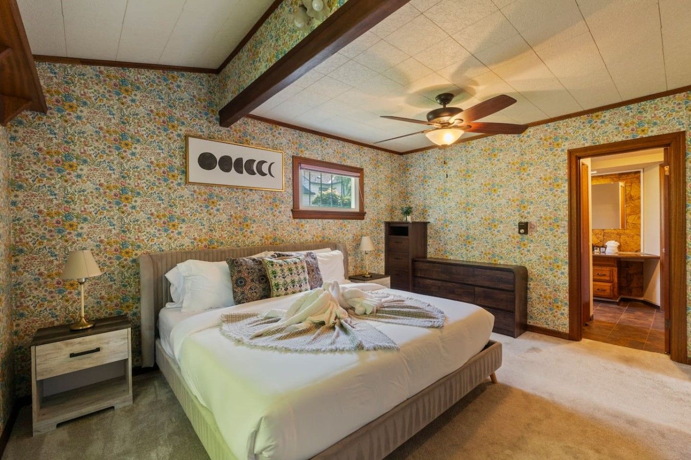 A bedroom with a bed, nightstand, dresser, and a ceiling fan.