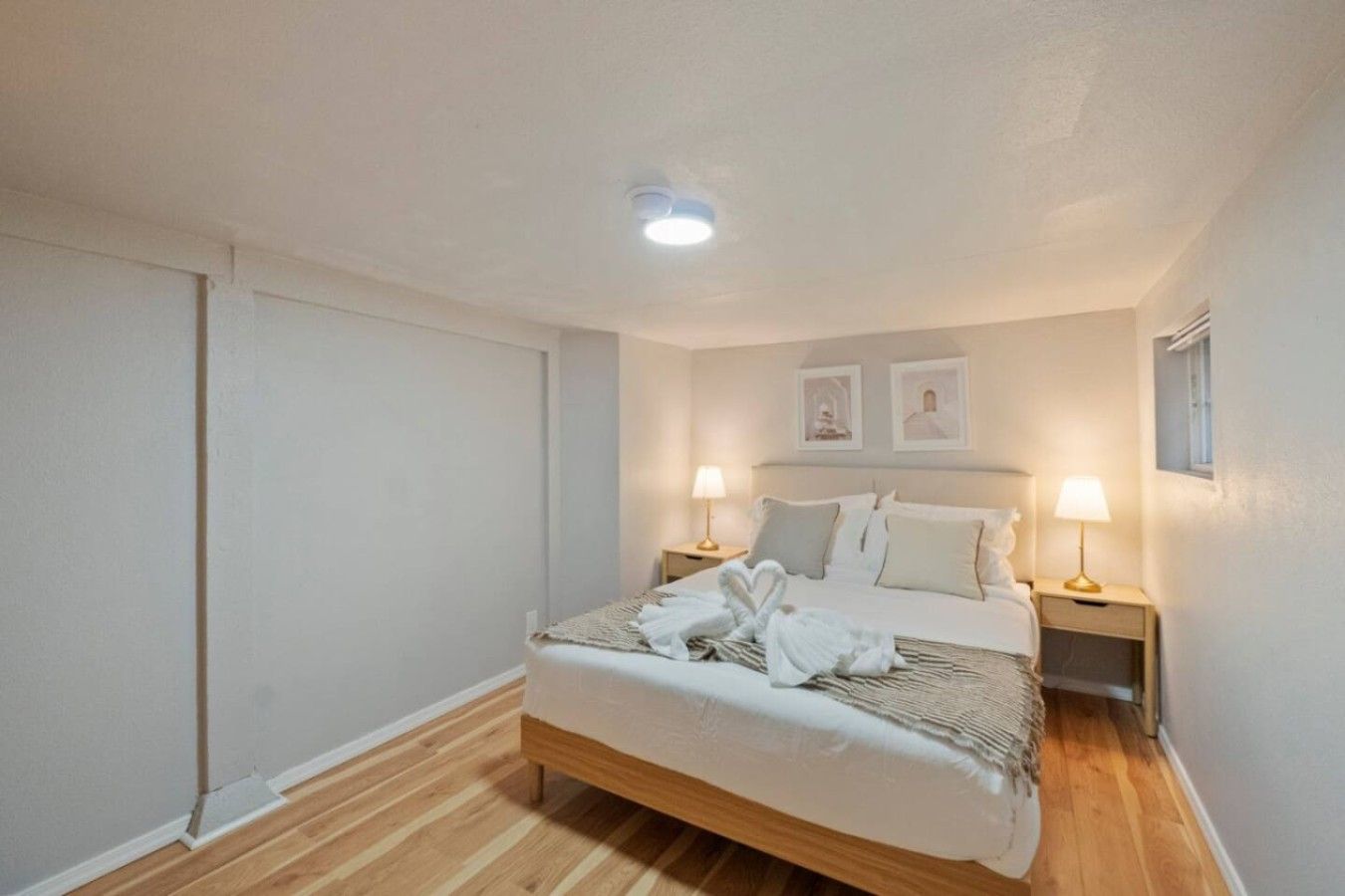 A bedroom with a bed, two bedside lamps, and a ceiling light.