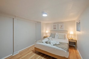 A bedroom with a bed, two bedside lamps, a ceiling light, and a window. - Cozy 1BR/1BA Lower Unit Near UW | Walk to Campus (Seattle)