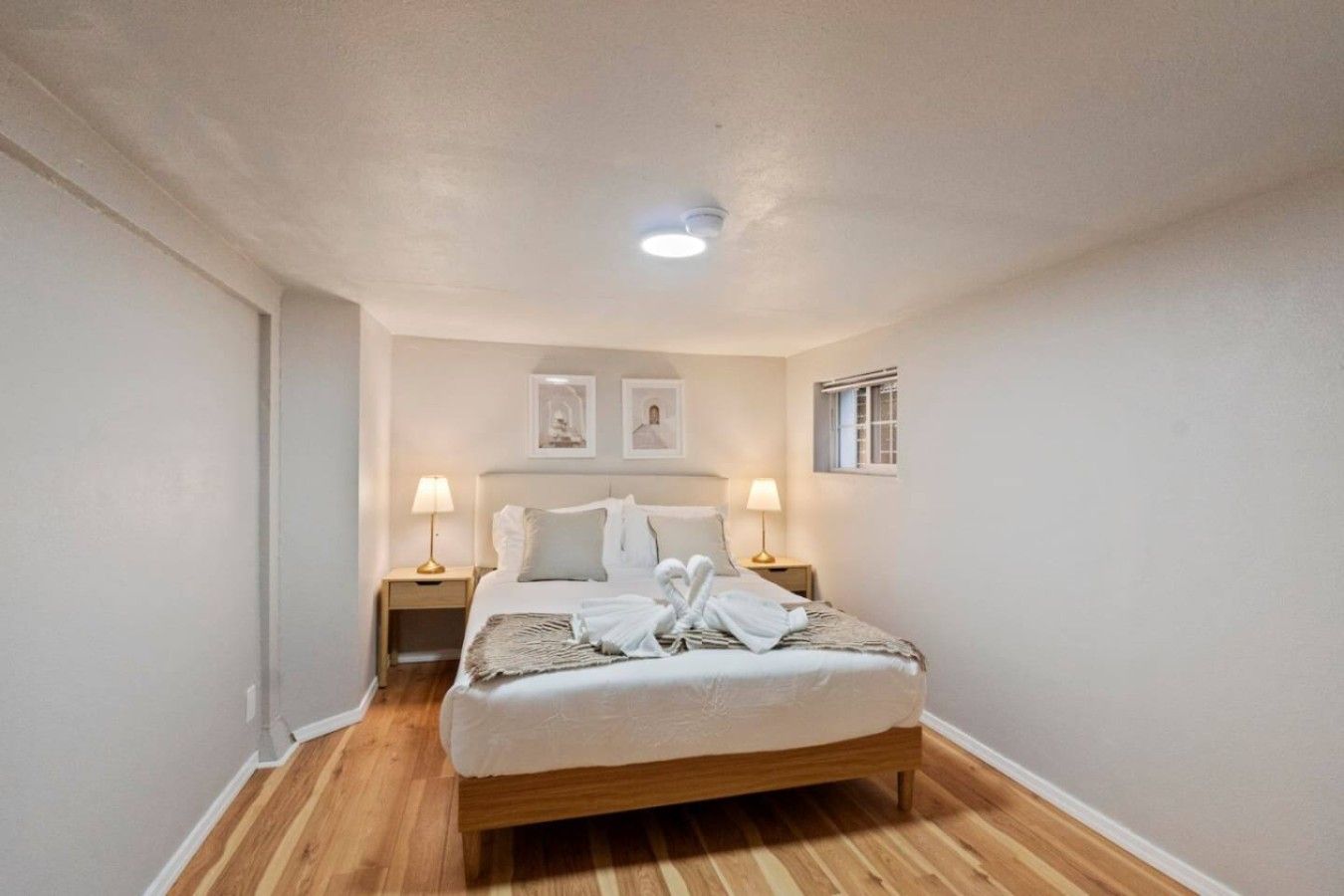 Una camera da letto con un letto singolo, due lampade da comodino, una finestra e una luce a soffitto.