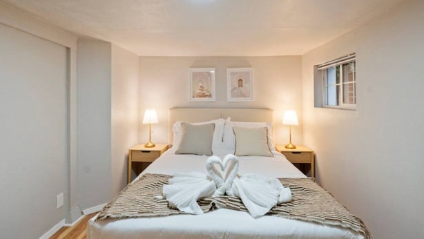 Ein Hotelzimmer mit einem Bett, zwei Nachttischlampen, einem Fenster und einer Deckenleuchte.