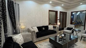Un salon moderne doté d’un ventilateur de plafond, d’un lustre et d’un grand miroir.