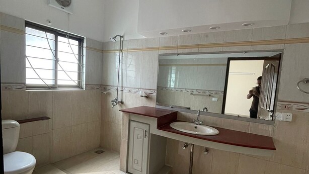 Ein Badezimmer mit Toilette, Waschbecken, Dusche und einem Fenster.