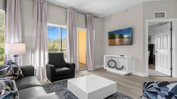 A modern living room with a sofa, armchair, and coffee table.