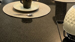A dining table with placemats, two coffee makers, and a view of a pool. - BONITO CASA MIRRA - Cozy house in Bonito with pool and space for family. (Bonito)