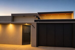 A modern building with a large garage door, a number '655' on the wall, and a sloped roof. - BONITO CASA MIRRA - Cozy house in Bonito with pool and space for family. (Bonito)